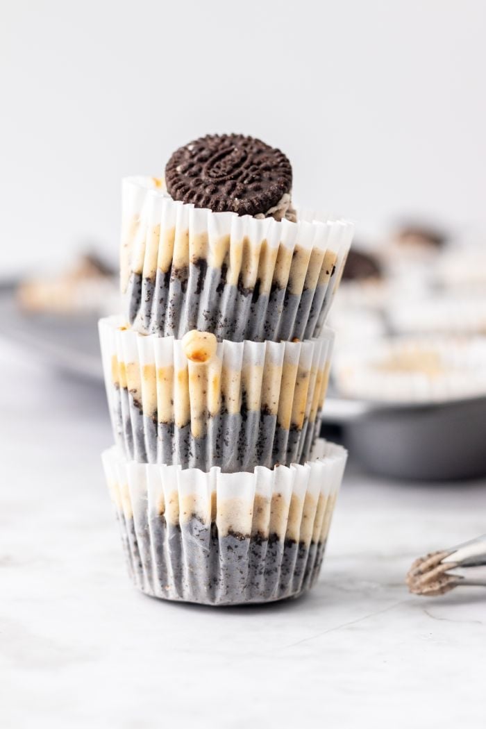 three Oreo cheesecake bites are stacked on top of each other